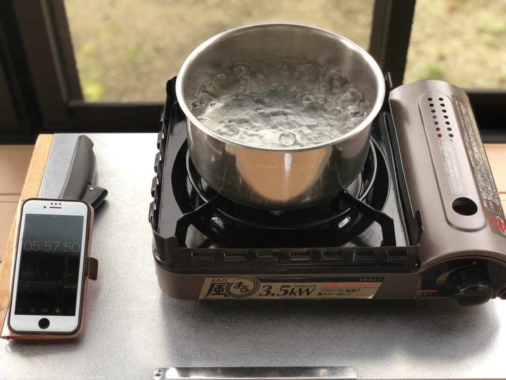カセットコンロに鍋を乗せお湯を沸騰させている画像